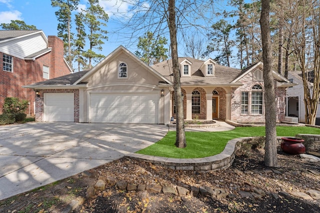11510 Walden Rd, Montgomery, TX 77356 - traditional-style home with brick siding, concrete driveway, an attached garage, and a shingled roof