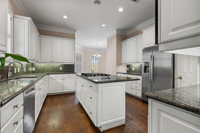 3908 Milton St, West University Place, TX 77005 - kitchen with appliances with stainless steel finishes, crown molding, a kitchen island, dark wood finished floors, and dark stone countertops