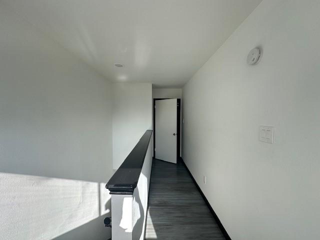 9009 Imogene St Unit E, Houston, TX 77036 - hallway featuring dark wood-style flooring and baseboards