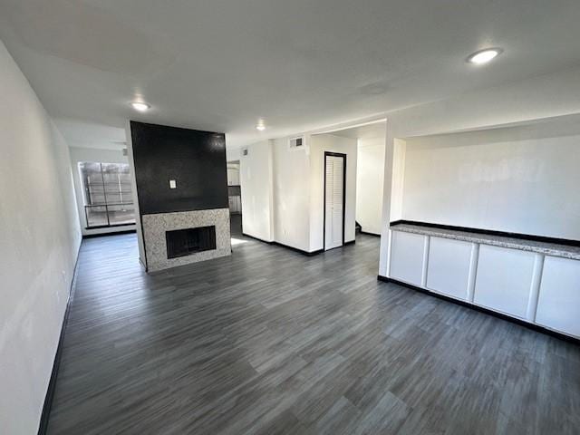 9009 Imogene St Unit E, Houston, TX 77036 - unfurnished living room with a large fireplace, dark wood-style flooring, and recessed lighting
