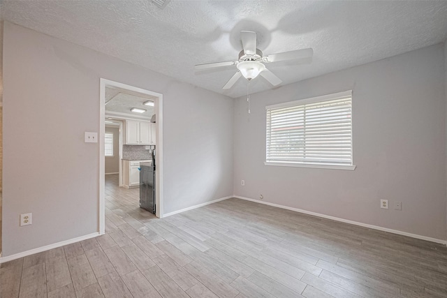 10423 Rancho Bernardo Ln, Sugar Land, TX 77498 - empty room with light wood finished floors, a textured ceiling, and a ceiling fan