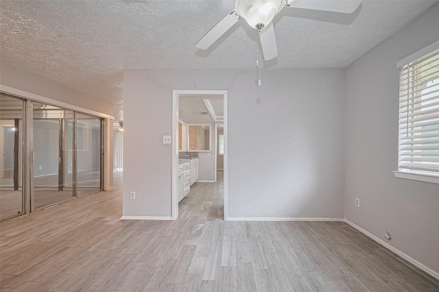 10423 Rancho Bernardo Ln, Sugar Land, TX 77498 - empty room featuring a textured ceiling, light wood-style floors, and ceiling fan
