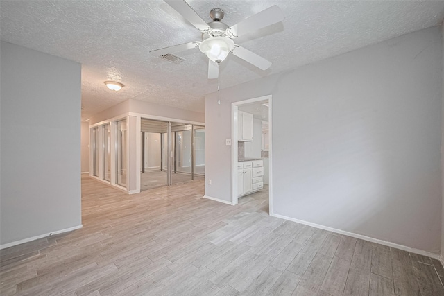 10423 Rancho Bernardo Ln, Sugar Land, TX 77498 - unfurnished living room featuring a ceiling fan, light wood finished floors, and a textured ceiling