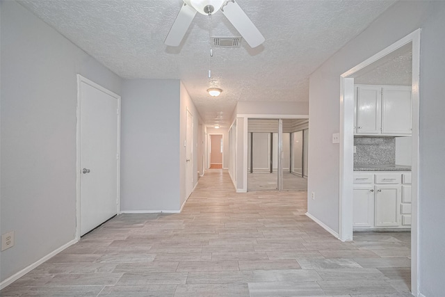 10423 Rancho Bernardo Ln, Sugar Land, TX 77498 - corridor with a textured ceiling and light wood finished floors
