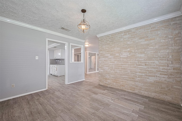 10423 Rancho Bernardo Ln, Sugar Land, TX 77498 - unfurnished room with wood finished floors, a textured ceiling, brick wall, ornamental molding, and a chandelier