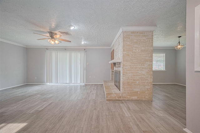 10423 Rancho Bernardo Ln, Sugar Land, TX 77498 - unfurnished living room featuring a ceiling fan, ornamental molding, light wood-style flooring, a textured ceiling, and a fireplace