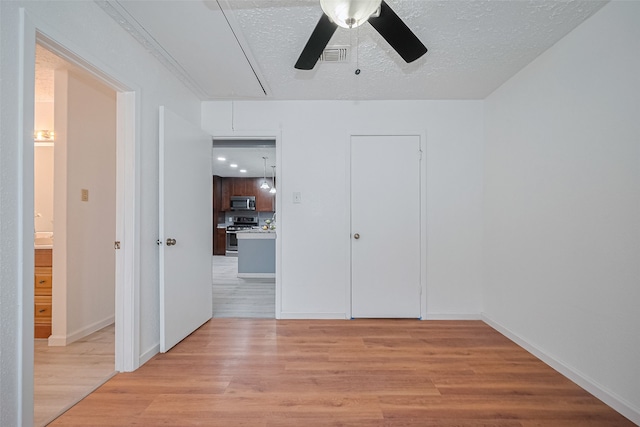 9302 Moorfield Ct, Houston, TX 77083 - unfurnished bedroom with attic access, light wood-style floors, a textured ceiling, and a ceiling fan