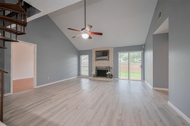 9302 Moorfield Ct, Houston, TX 77083 - unfurnished living room with high vaulted ceiling, a ceiling fan, wood finished floors, a brick fireplace, and stairway