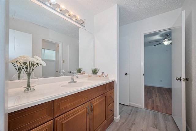 9302 Moorfield Ct, Houston, TX 77083 - bathroom with wood finished floors, vanity, a textured ceiling, and a ceiling fan