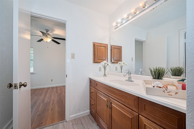 9302 Moorfield Ct, Houston, TX 77083 - bathroom with vanity, wood finished floors, ceiling fan, and a textured ceiling