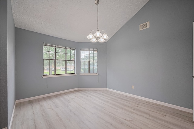 9302 Moorfield Ct, Houston, TX 77083 - empty room featuring a textured ceiling, wood finished floors, a chandelier, and vaulted ceiling