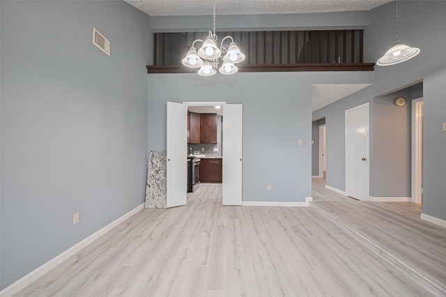 9302 Moorfield Ct, Houston, TX 77083 - empty room featuring a chandelier, light wood-type flooring, and a towering ceiling