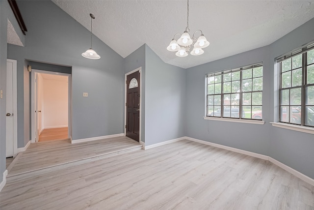 9302 Moorfield Ct, Houston, TX 77083 - empty room featuring light wood-type flooring, a textured ceiling, a chandelier, and vaulted ceiling