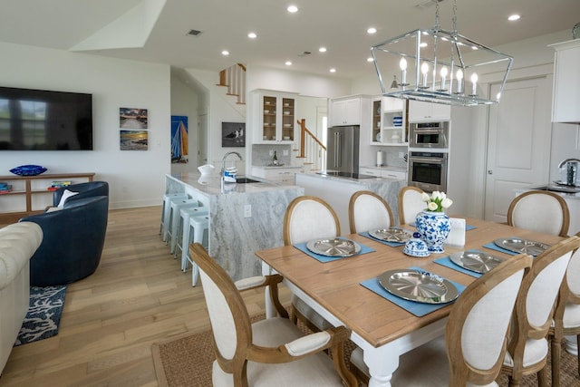 18414 Indian Beach Ct, Galveston, TX 77554 - dining room featuring light wood-style floors, stairs, recessed lighting, and a chandelier