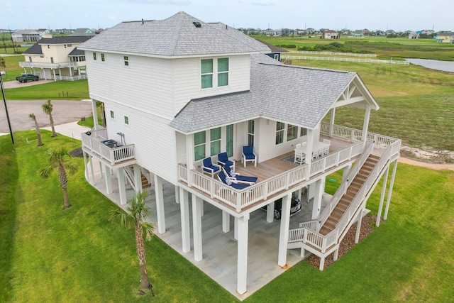 18414 Indian Beach Ct, Galveston, TX 77554 - back of house featuring a shingled roof, stairs, and a yard