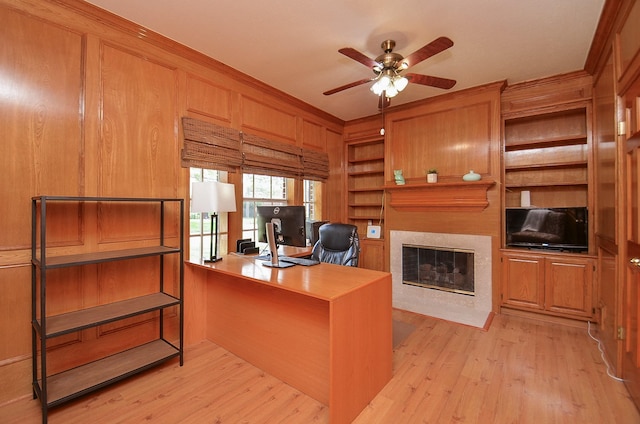 15915 Sweetwater Creek Dr, Houston, TX 77095 - home office with a ceiling fan, built in features, a fireplace, light wood-type flooring, and wood walls