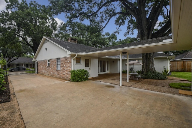10035 Ella Lee Ln, Houston, TX 77042 - view of front facade featuring concrete driveway, a chimney, a patio area, and brick siding