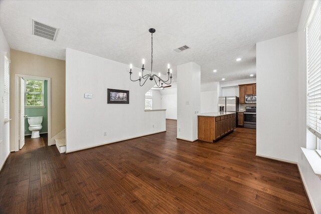 3324 Masters Point Dr, Houston, TX 77091 - kitchen featuring stainless steel appliances, brown cabinets, a chandelier, dark wood-style flooring, and open floor plan
