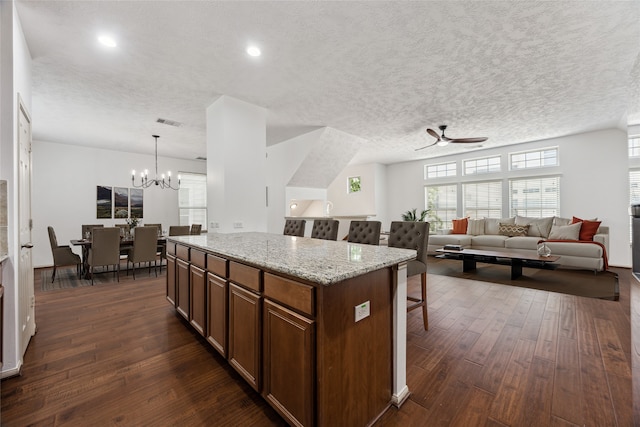 3324 Masters Point Dr, Houston, TX 77091 - kitchen featuring dark wood-style flooring, ceiling fan, a breakfast bar area, a kitchen island, and a chandelier
