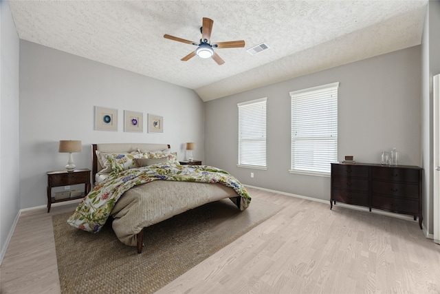 3324 Masters Point Dr, Houston, TX 77091 - bedroom with light wood-style flooring, a textured ceiling, lofted ceiling, and ceiling fan