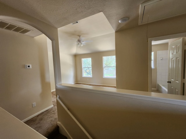 19843 Portlick Ct, Katy, TX 77449 - hallway featuring carpet flooring, attic access, arched walkways, and a textured ceiling