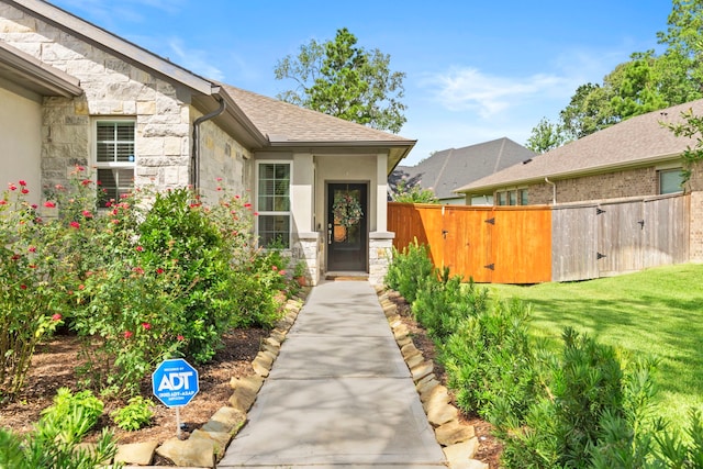 247 N Wild Petunia Trl, Montgomery, TX 77316 - view of exterior entry with stone siding, a gate, and roof with shingles