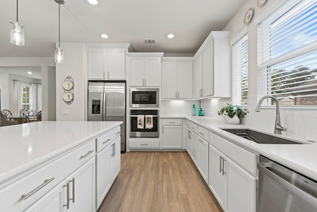 247 N Wild Petunia Trl, Montgomery, TX 77316 - kitchen with appliances with stainless steel finishes, decorative backsplash, light countertops, recessed lighting, and white cabinetry