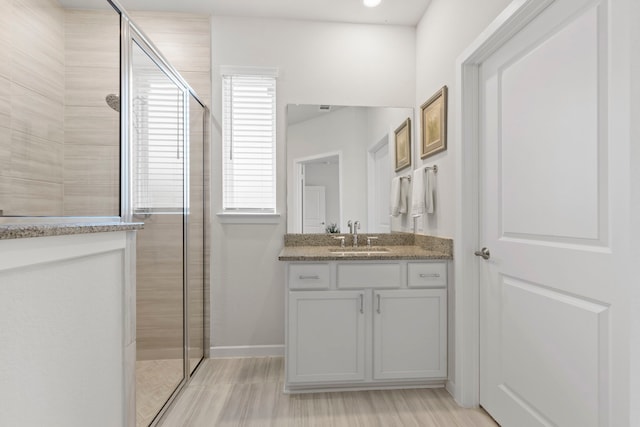247 N Wild Petunia Trl, Montgomery, TX 77316 - bathroom featuring tiled shower, vanity, and wood finished floors