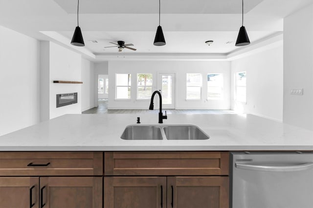 1005 Lake View Dr, Montgomery, TX 77356 - kitchen with stainless steel dishwasher, open floor plan, a raised ceiling, and light stone counters