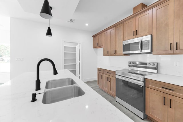 1005 Lake View Dr, Montgomery, TX 77356 - kitchen featuring stainless steel appliances, light wood-style flooring, hanging light fixtures, brown cabinets, and recessed lighting