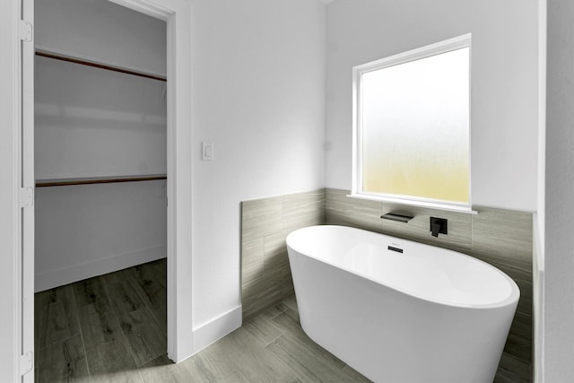 1005 Lake View Dr, Montgomery, TX 77356 - bathroom featuring a soaking tub, a walk in closet, and tile walls