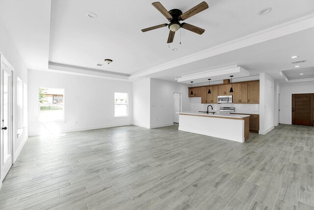 1005 Lake View Dr, Montgomery, TX 77356 - unfurnished living room featuring a raised ceiling, light wood-style flooring, ceiling fan, and recessed lighting
