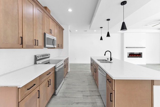 1005 Lake View Dr, Montgomery, TX 77356 - kitchen featuring stainless steel appliances, recessed lighting, hanging light fixtures, a center island with sink, and light wood-style flooring