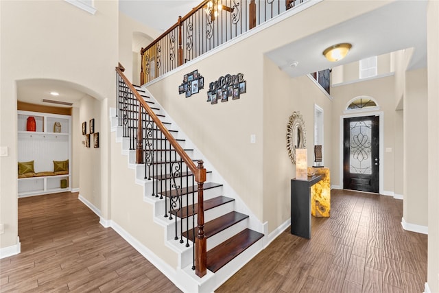 3614 Bonnie Bend Ln, Katy, TX 77494 - foyer entrance with a towering ceiling, arched walkways, wood finished floors, and stairway