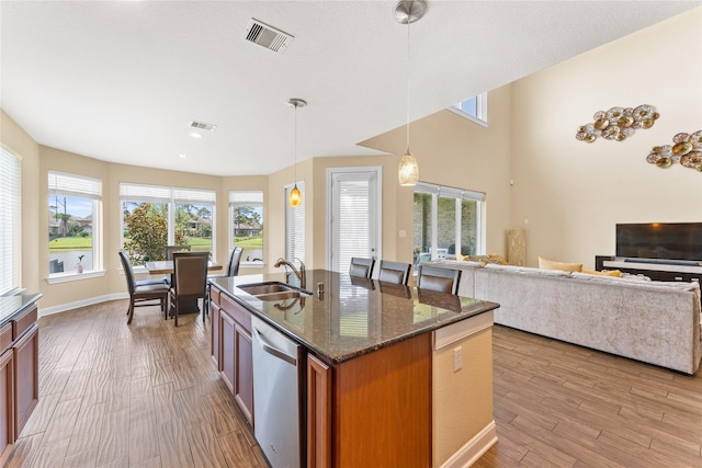 3614 Bonnie Bend Ln, Katy, TX 77494 - kitchen with stainless steel dishwasher, brown cabinetry, wood finished floors, hanging light fixtures, and recessed lighting