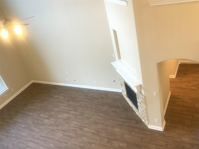 3614 Bonnie Bend Ln, Katy, TX 77494 - unfurnished living room with dark wood-style flooring, arched walkways, and a fireplace