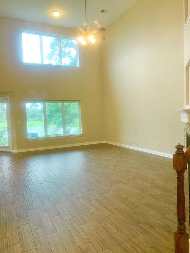3614 Bonnie Bend Ln, Katy, TX 77494 - empty room with wood finished floors, a fireplace, and a high ceiling