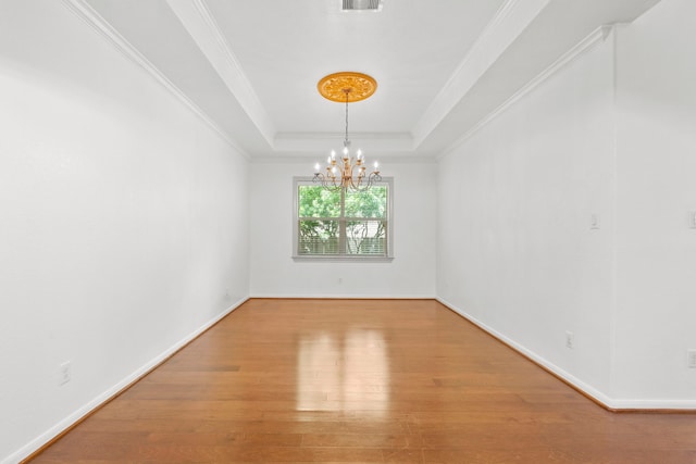 1109 Jacobs Lake Blvd, Conroe, TX 77384 - spare room with a chandelier, wood finished floors, a raised ceiling, and crown molding