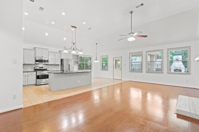 1109 Jacobs Lake Blvd, Conroe, TX 77384 - unfurnished living room with a ceiling fan, plenty of natural light, high vaulted ceiling, light wood-style flooring, and recessed lighting