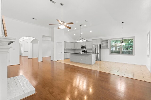 1109 Jacobs Lake Blvd, Conroe, TX 77384 - unfurnished living room with a ceiling fan, vaulted ceiling, arched walkways, recessed lighting, and light wood-type flooring