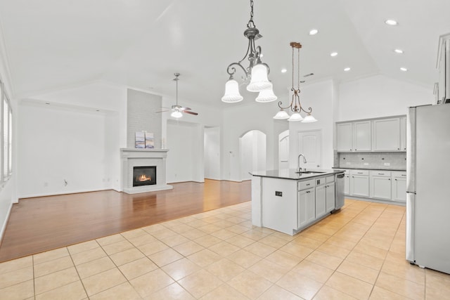 1109 Jacobs Lake Blvd, Conroe, TX 77384 - kitchen featuring freestanding refrigerator, high vaulted ceiling, a ceiling fan, light tile patterned floors, and dark countertops