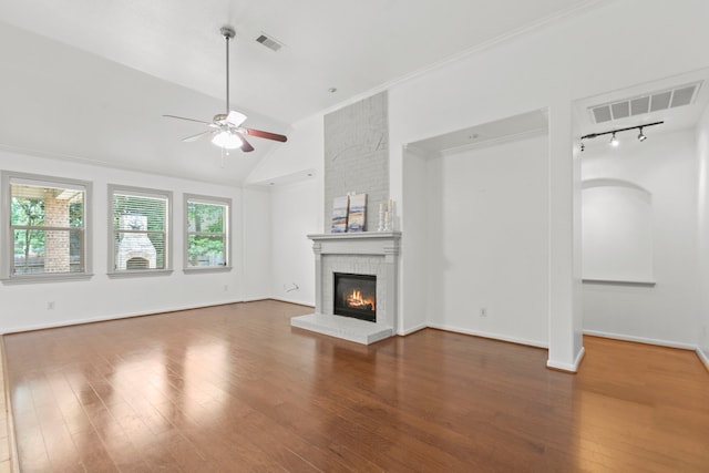 1109 Jacobs Lake Blvd, Conroe, TX 77384 - unfurnished living room with a ceiling fan, a fireplace, vaulted ceiling, wood finished floors, and rail lighting