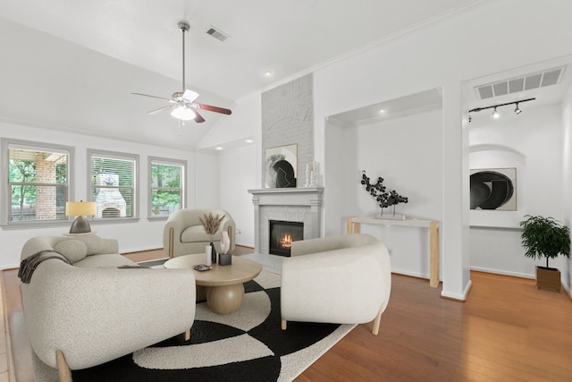 1109 Jacobs Lake Blvd, Conroe, TX 77384 - living room featuring a brick fireplace, wood finished floors, lofted ceiling, ceiling fan, and crown molding
