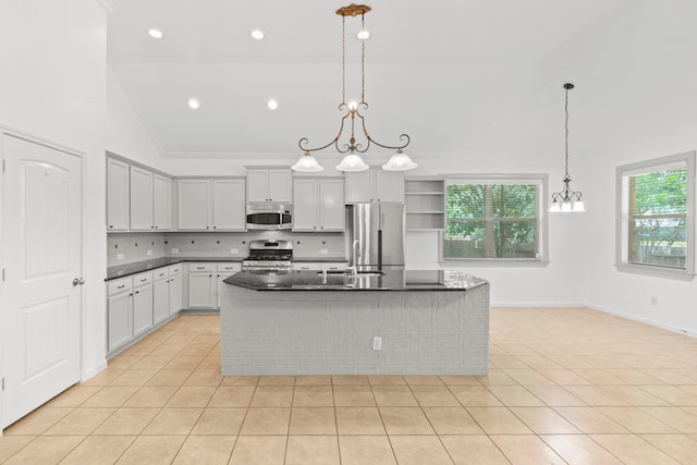 1109 Jacobs Lake Blvd, Conroe, TX 77384 - kitchen with appliances with stainless steel finishes, tasteful backsplash, light tile patterned floors, ornamental molding, and a kitchen island with sink