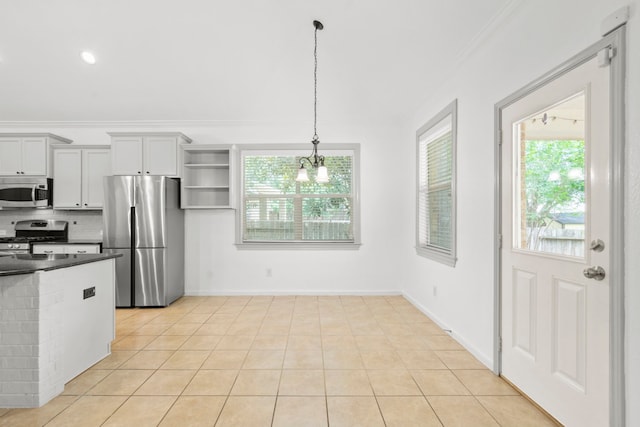 1109 Jacobs Lake Blvd, Conroe, TX 77384 - kitchen with stainless steel appliances, a chandelier, dark countertops, healthy amount of natural light, and ornamental molding
