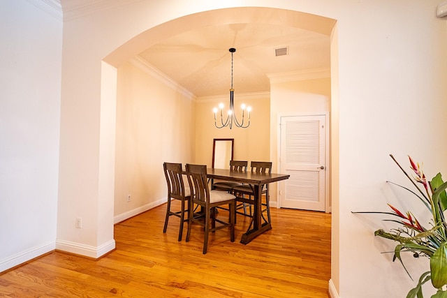 5346 Mcculloch Cir, Houston, TX 77056 - dining space with arched walkways, light wood-style flooring, crown molding, and a chandelier