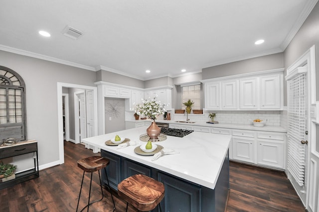 8618 Aldeburgh Ct, Spring, TX 77379 - kitchen featuring white cabinetry, tasteful backsplash, a kitchen breakfast bar, dark wood finished floors, and recessed lighting