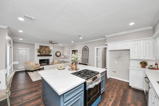 8618 Aldeburgh Ct, Spring, TX 77379 - kitchen with stainless steel appliances, a large fireplace, recessed lighting, a ceiling fan, and white cabinets