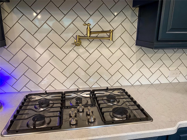 10011 Serenity Grove Dr, Missouri City, TX 77459 - kitchen view of pot filler, stainless steel gas cooktop, decorative backsplash, and blue cabinetry