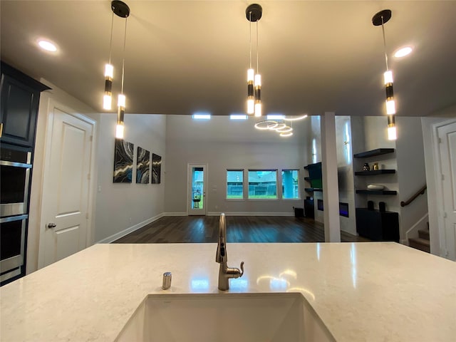 10011 Serenity Grove Dr, Missouri City, TX 77459 - kitchen featuring wood finished floors, open floor plan, stainless steel double oven, hanging light fixtures, and recessed lighting